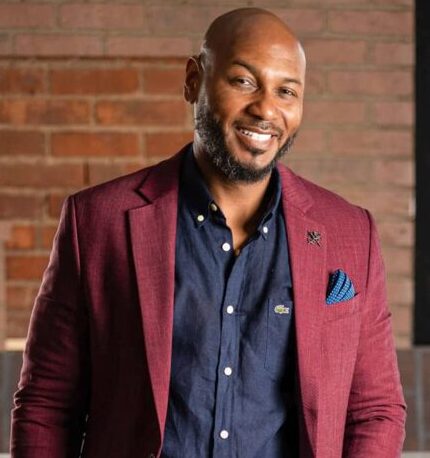 Dr. Marlon Gray, smiling man in burgundy blazer with navy blue button up