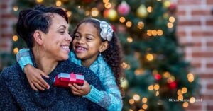 daughter hugging mother from behind in front of a Christmas tree